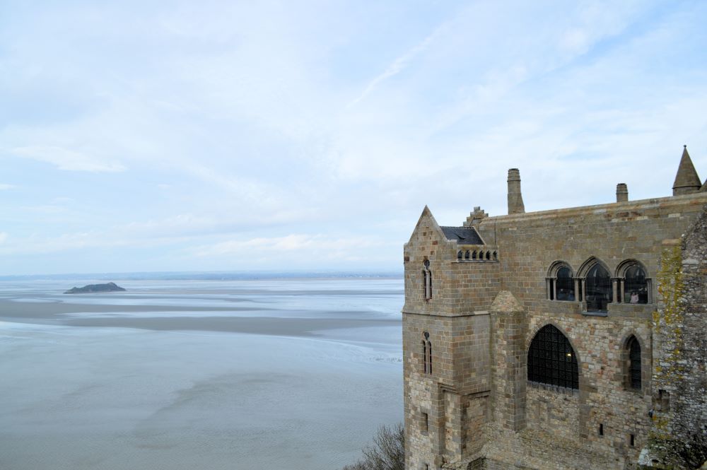 paysage de la baie du Mont Saint Michel avec un bâtiment de l'abbaye au premier plan