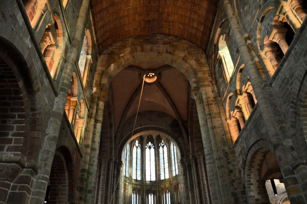 intérieur de l'église abbatiale du Mont Saint Michel avec une nef romane et un chœur gothique