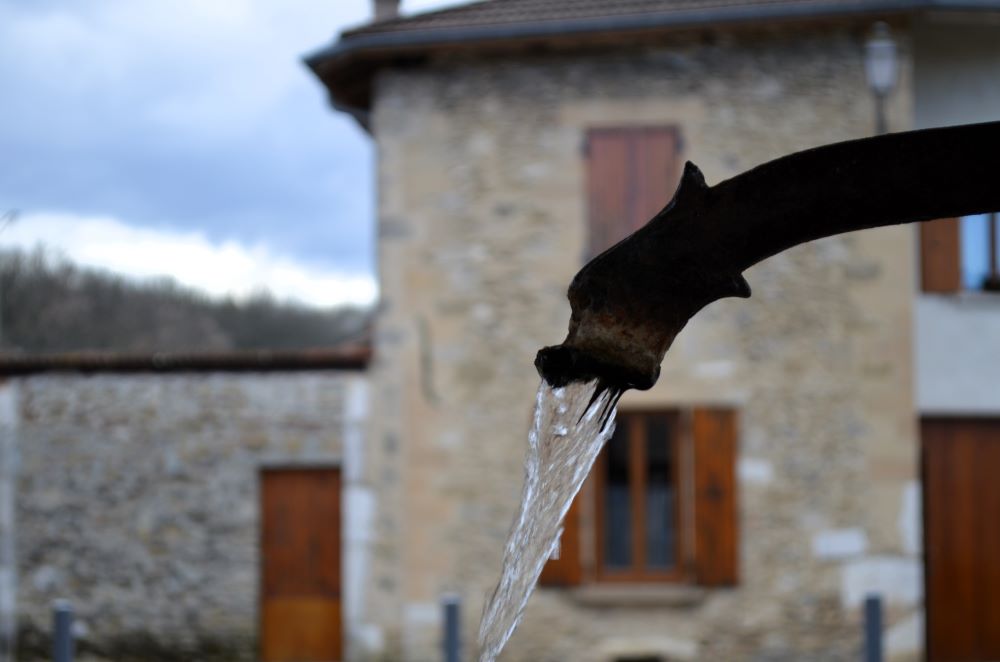 une fontaine qui coule au cœur d'un village