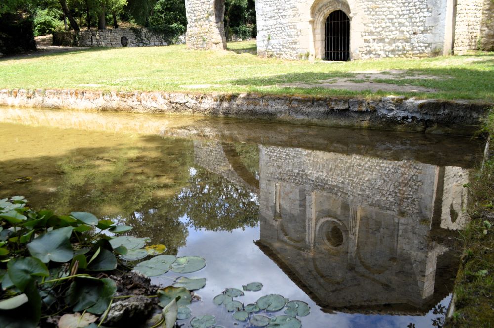 reflet d'une chapelle romane dans un bassin