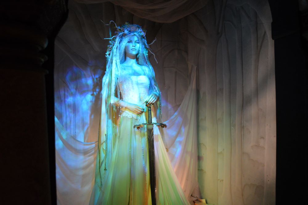 une femme habillée en blanc et tenant une épée médiévale