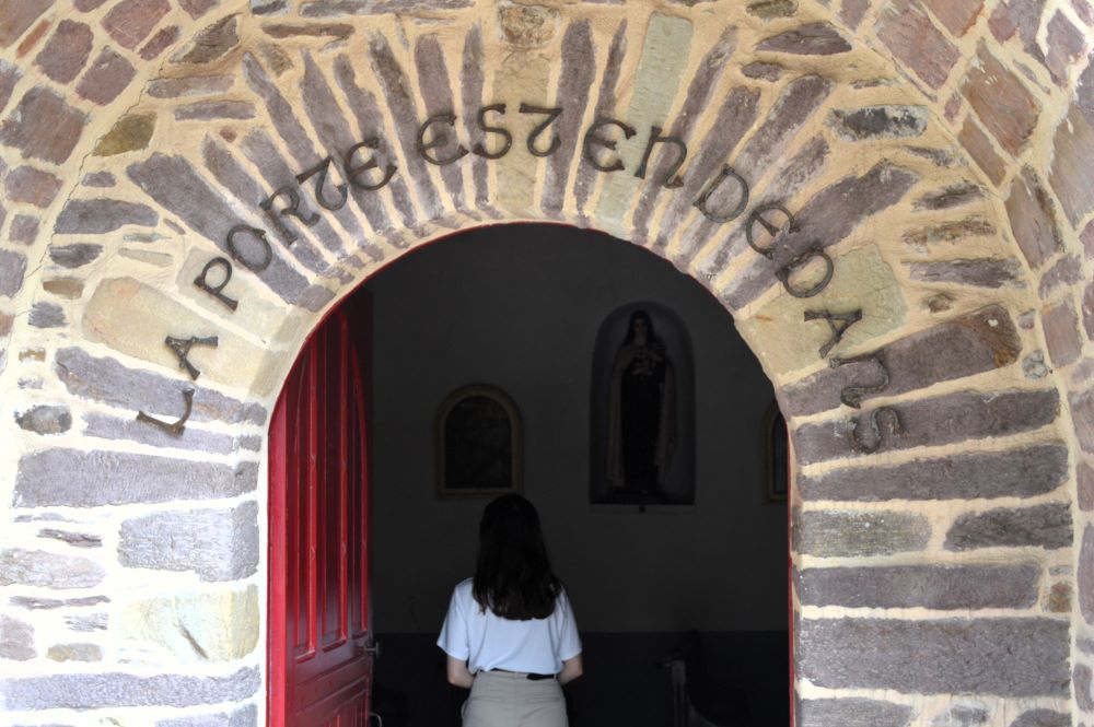 porte dans un mur en pierre surmontée de l'inscription "La porte est en dedans"