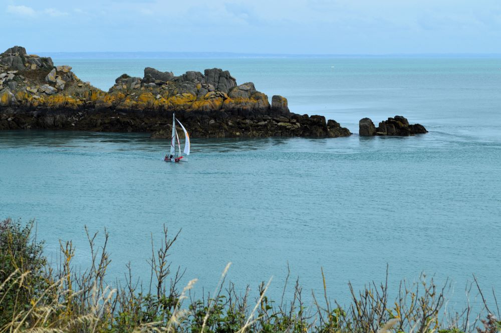 voilier devant une île rocheuse