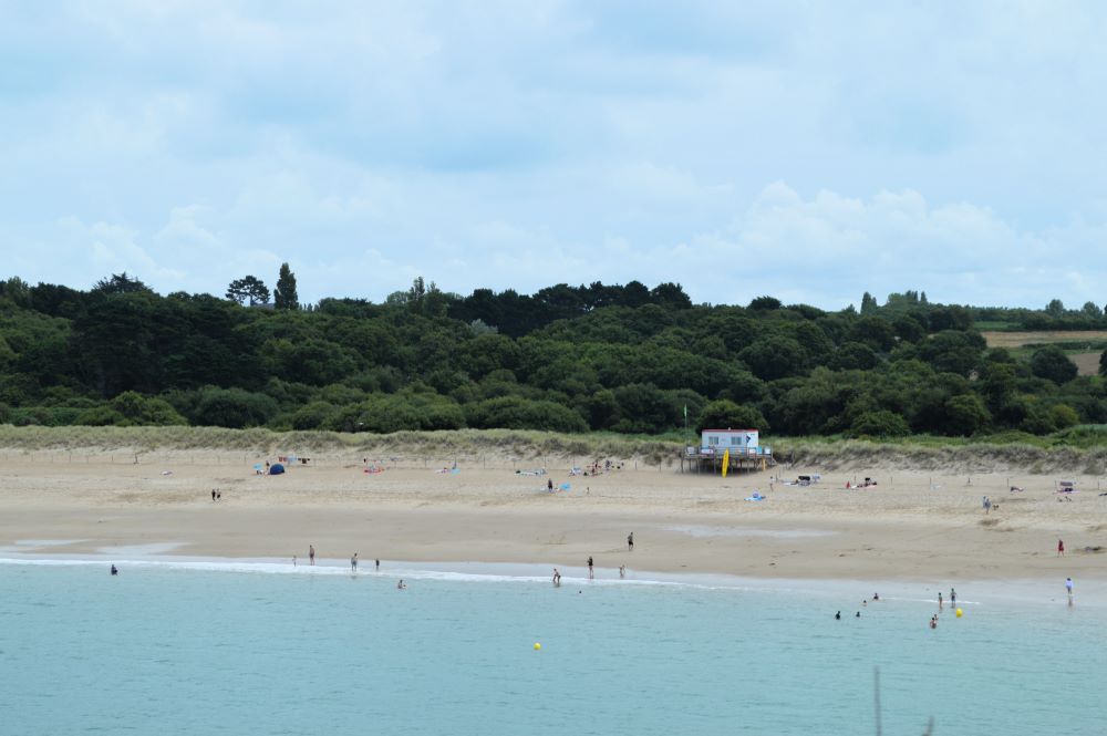 plage vue depuis la mer avec la campagne en arrière plan