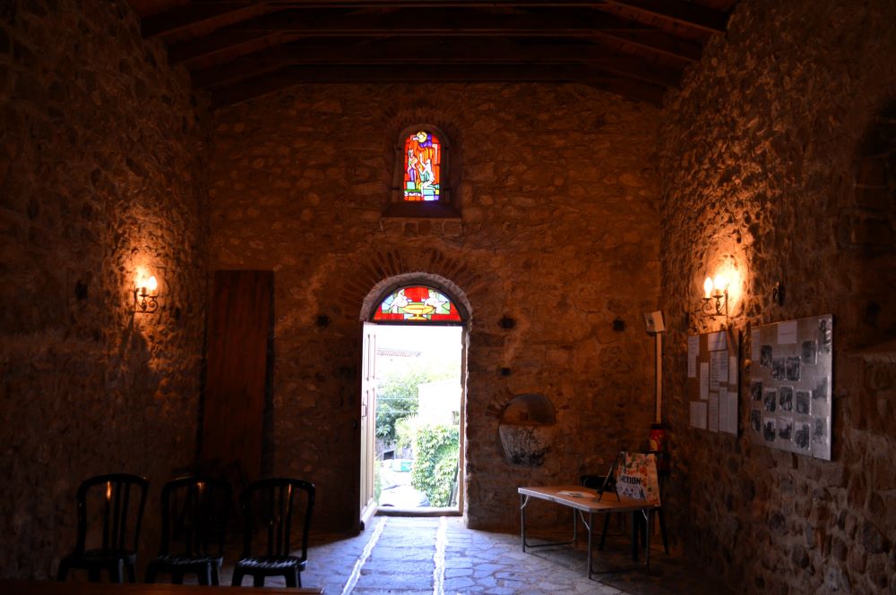 intérieur d'une chapelle romane avec des vitraux contemporains