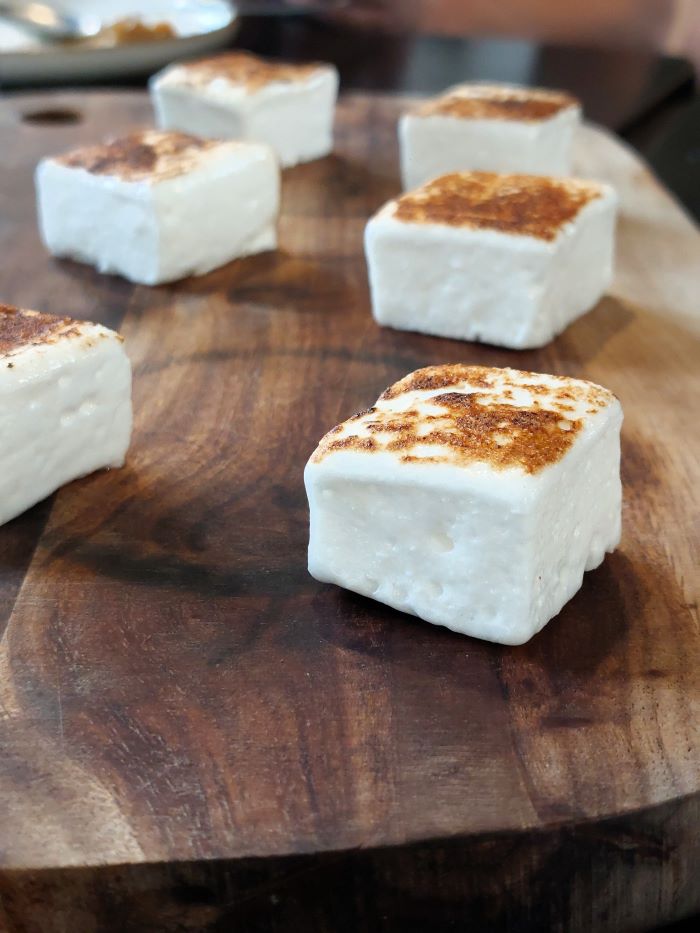 6 guimauves sur une planche en bois