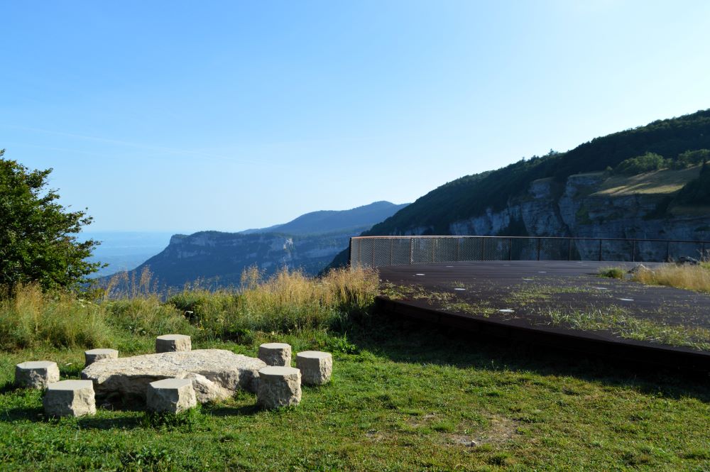 paysage de montagne avec un belvédère métallique et une table et des sièges de pique nique en pierre