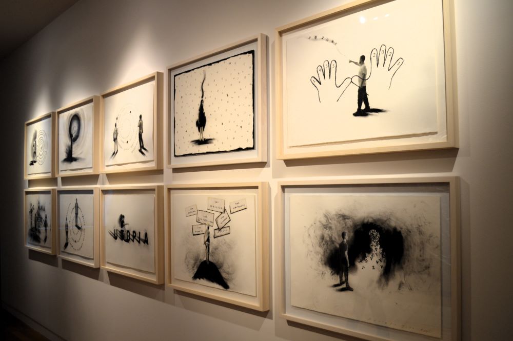 10 tableaux en noir sur papier blanc accrochés sur un mur