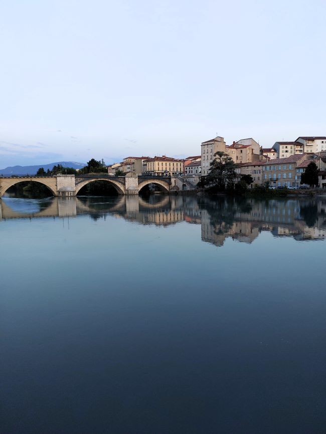 lumières de fin de journée sur la rivière avec le pont et les bâtiments qui se reflètent