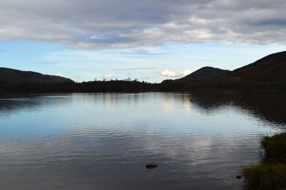 au bord d'un lac dominé par une montagne en fin de journée