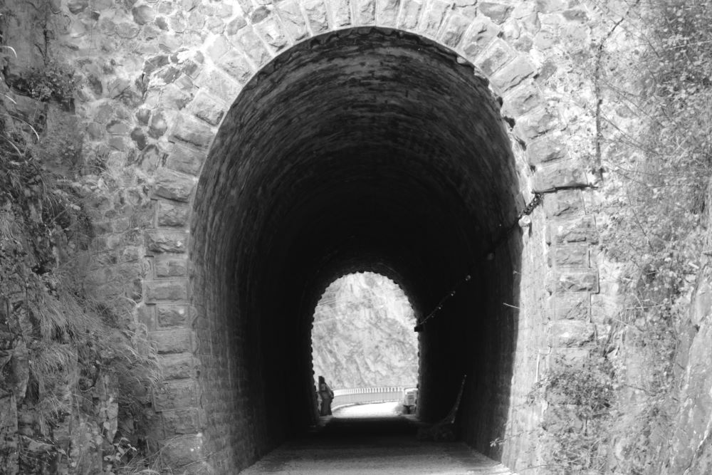 un tunnel sur l'ancienne voie ferrée piétonnisé en noir et blanc