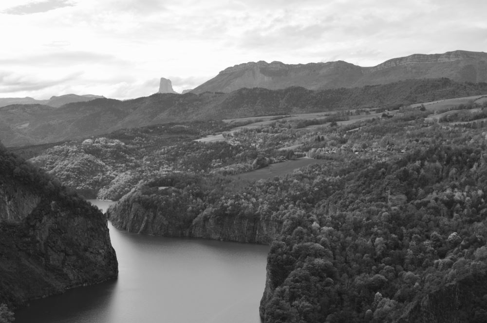vue en noir et blanc du lac de Monteynard entre les falaises du canyon du Drac avec la silhouette du Mont Aiguille et du Vercors dans le fond