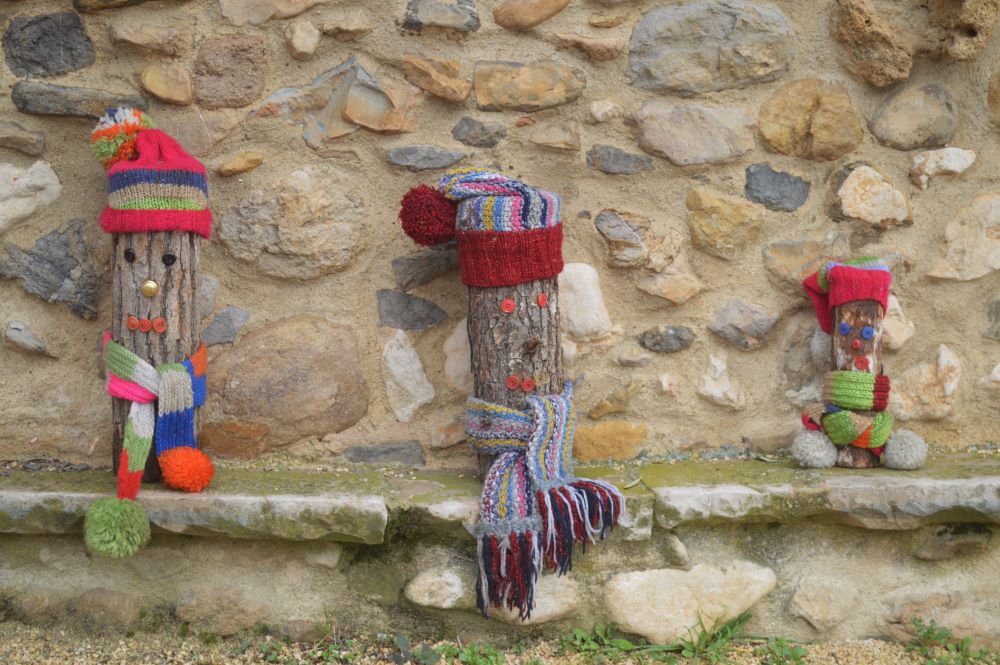 3 rondins de bois transformés en personnages à l'aide d'accessoire en tissu