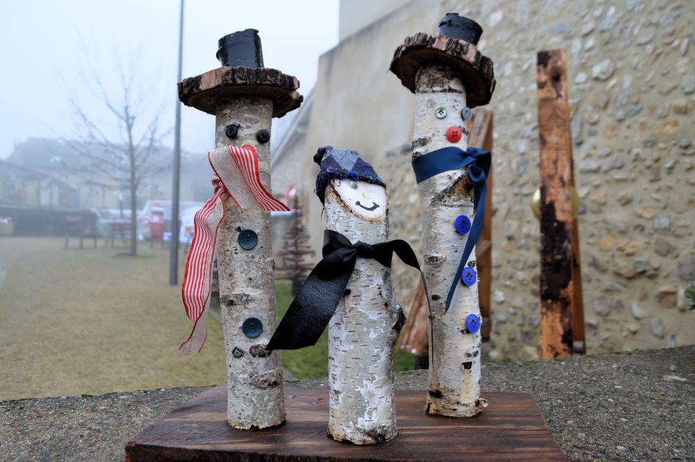 3 rondins de bois transformés en personnages à l'aide d'accessoire en tissu