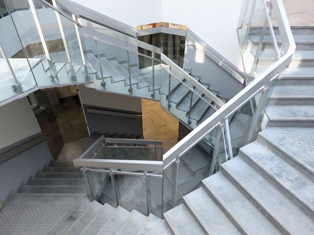 escalier à double révolution avec garde corps en aluminium et panneaux de verre