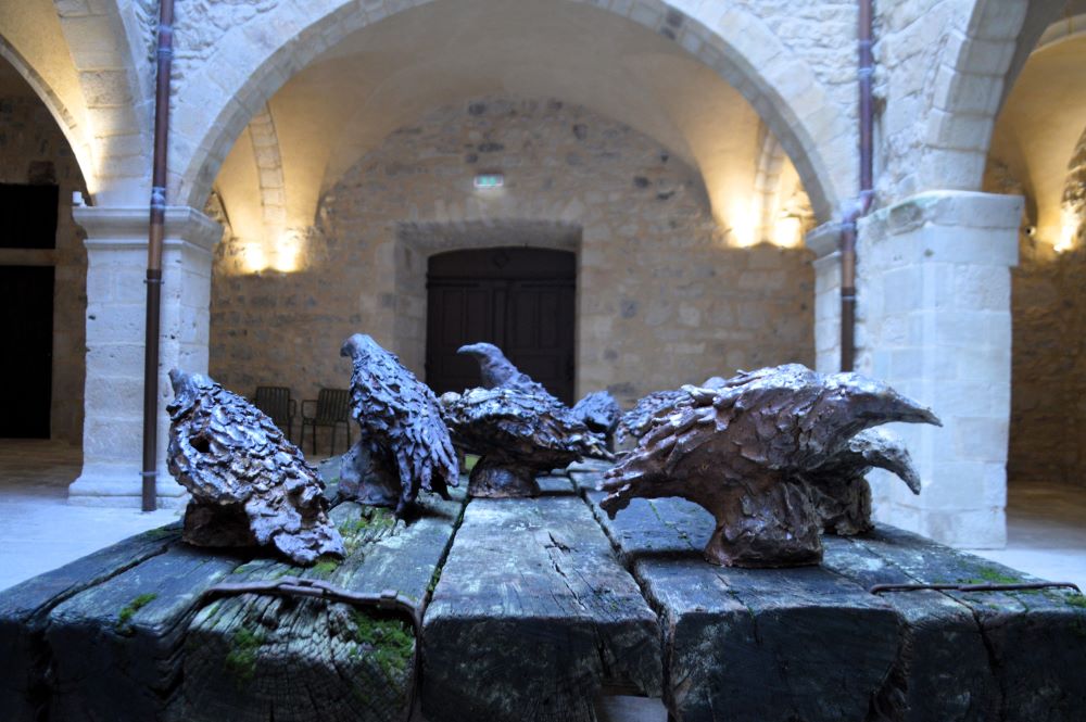 sculpture contemporaine représentant des corbeaux en bronze sur une table en bois