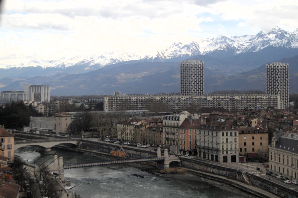 la ville de Grenoble avec le village olympique dominée par les montagnes enneigées