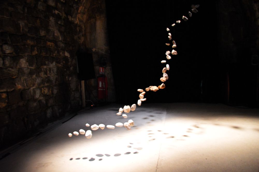 une installation artistique contemporaine où des cailloux semblent en lévitation dans l'air