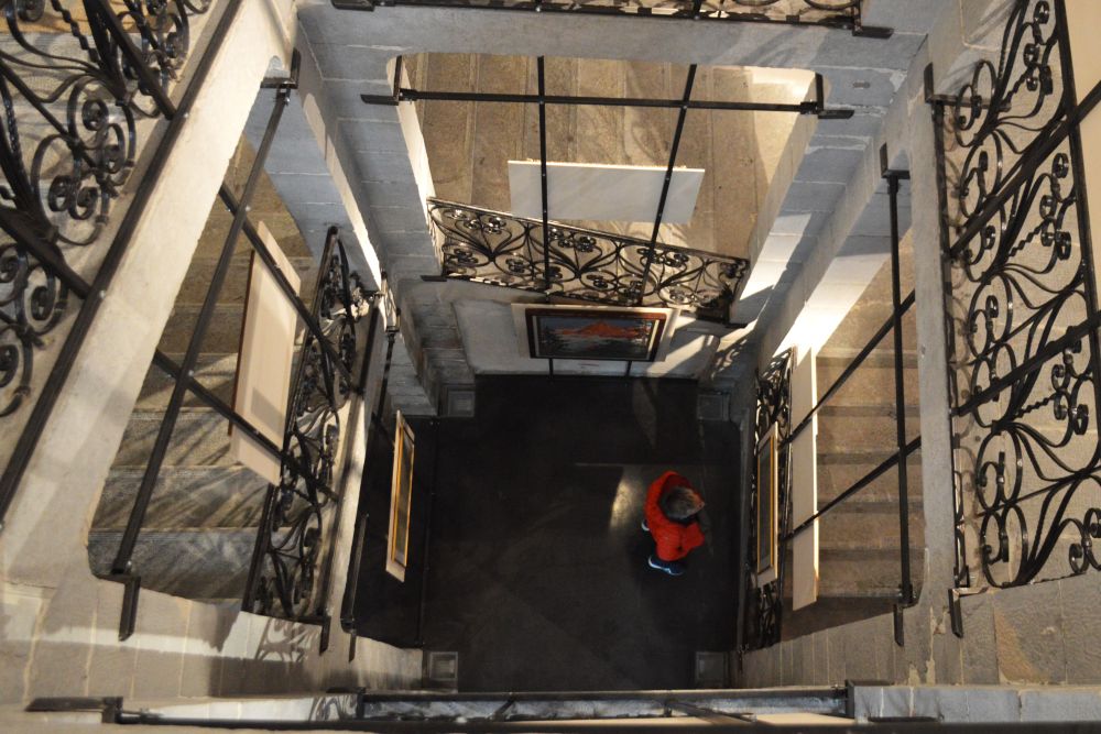 une cage d'escalier ancienne avec des rambardes en fer forgé