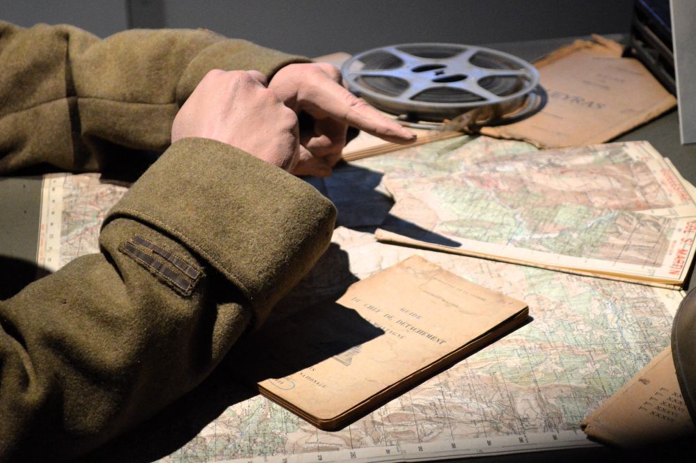 gros plan sur les mains d'un officier en uniforme de la seconde guerre mondiale étudiant des cartes topographiques de montagne