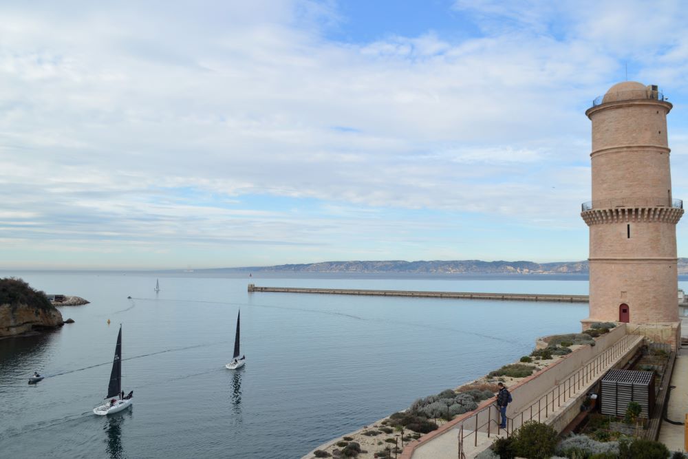 des voiliers sortent du Vieux Port en passant devant la tour du Fanal