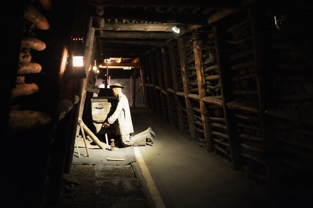 un mineur à genoux pour creuser dans une galerie de mine de charbon au 19ième siècle