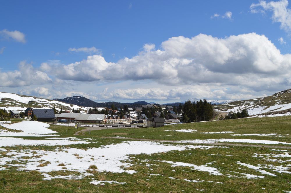 paysage de montagne avec des plaques de neige laissant apparaitre l'herbe