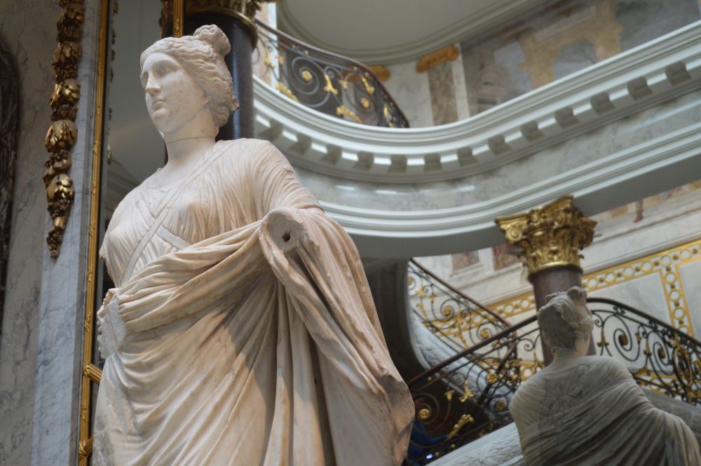 une sculpture antique représentant une femme au pied de l'escalier