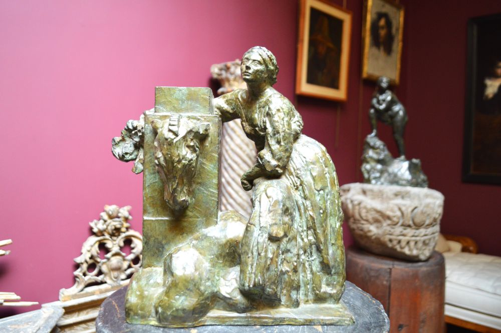 dans une chambre, gros plan sur un bronze représentant une femme assise de trois-quarts et appuyée sur une colonne 