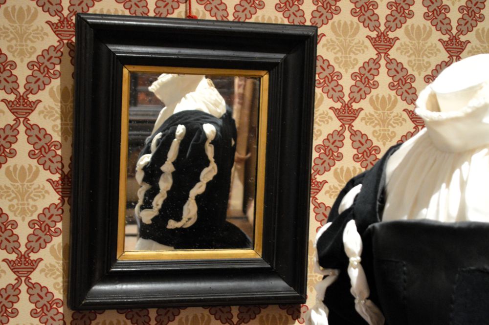 Reflet d'une robe de style Renaissance dans un miroir posé au mur