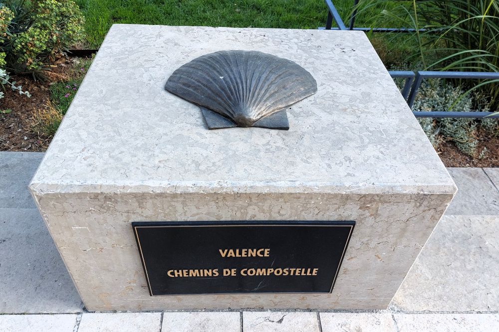 une borne sur laquelle est posée une coquille saint Jacques en bronze marque le départ valentinois du chemin de Compostelle