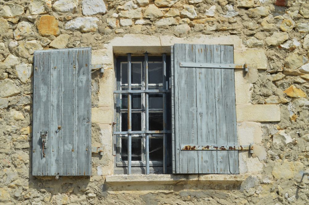 fenêtre avec volet en bois sur une maison ancienne