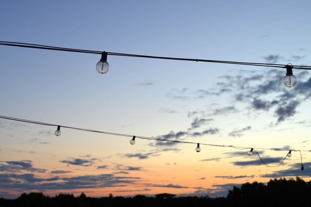 une guirlande d'ampoules façon ginguette dans le coucher du soleil