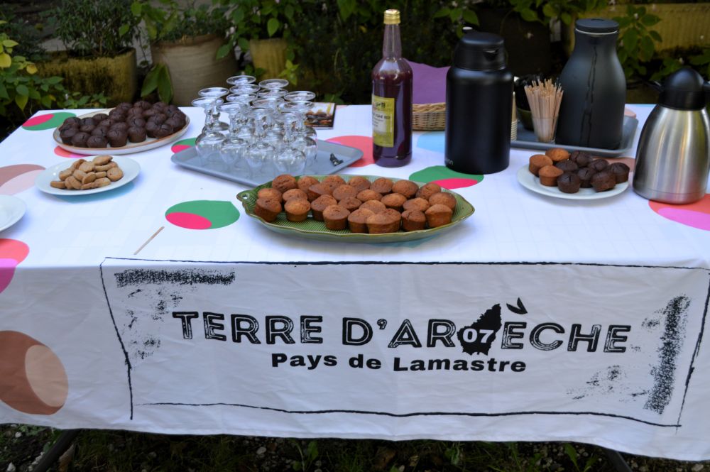 table avec des petits gâteaux, du jus de fruits et des thermos de café