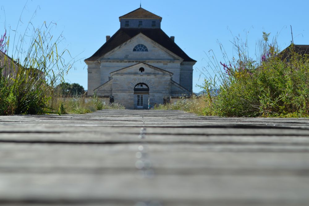 la maison du directeur de la saline royale d'Arc et Senans avec un cheminement en bois au premier plan