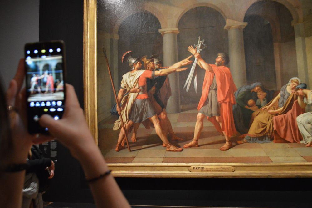 personne prenant une photo dans l'exposition temporaire Jacques Louis David au musée du Louvre