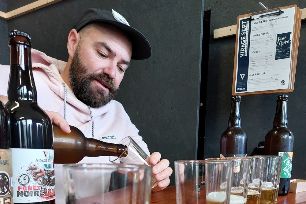 un homme verse de la bière dans des verres