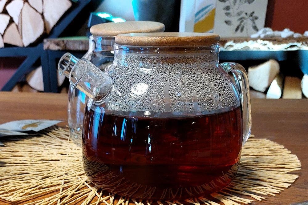 théière en verre remplie de thé noir