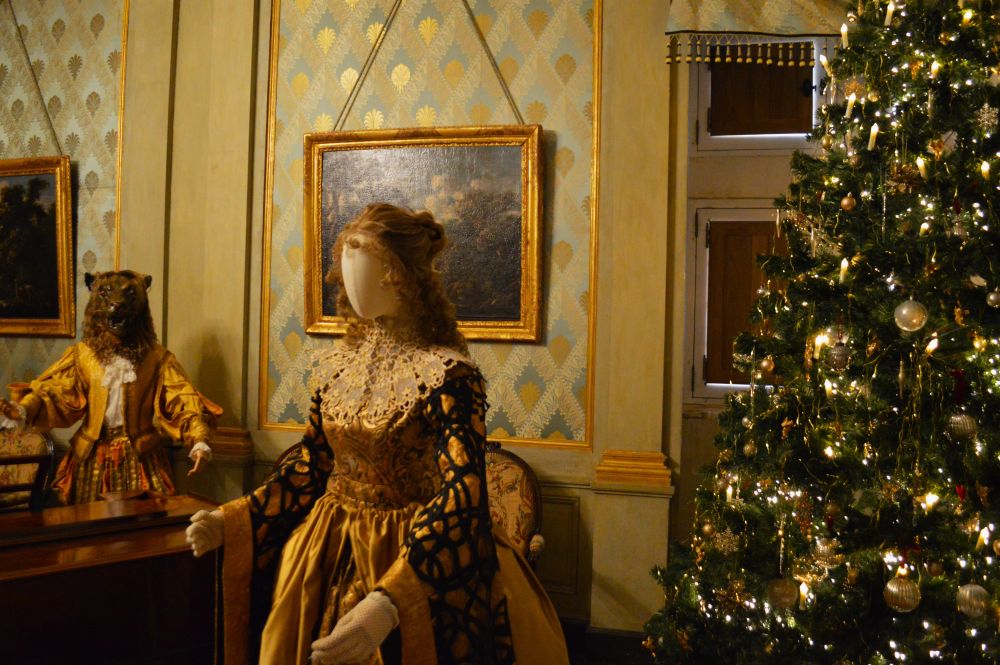 deux personnages baroques à côté d'un sapin de Noël