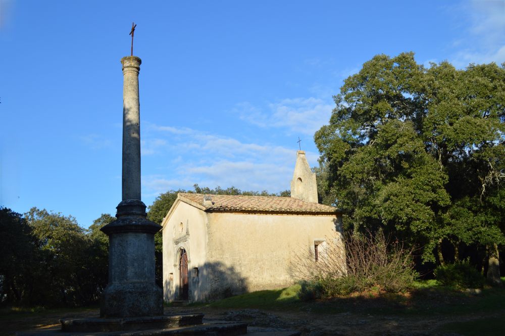 une petite chapelle et une croix marquant un carrefour dans les bois