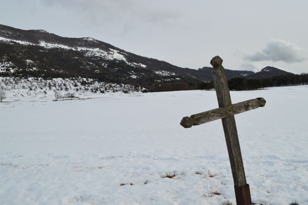 Croix en bois dans un paysage de montagne enneigé