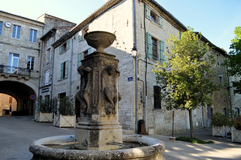 une fontaine sur une place à Barjac