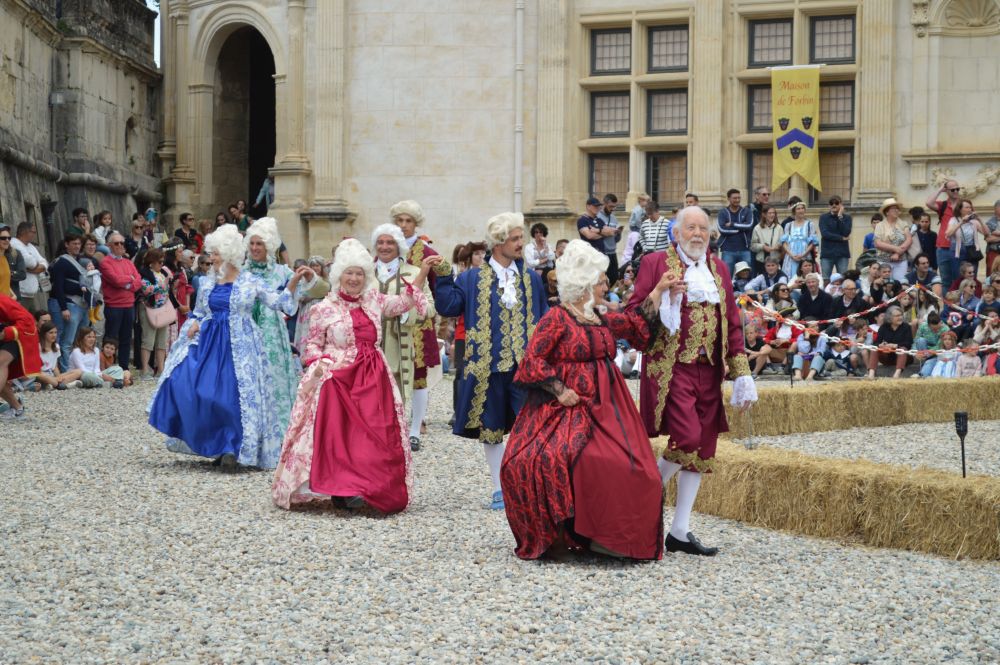 défilé de personnes en costumes baroques