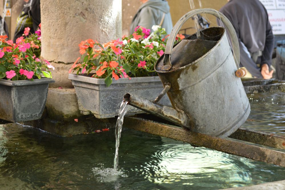 fontaine qui se déverse dans un arrosoir