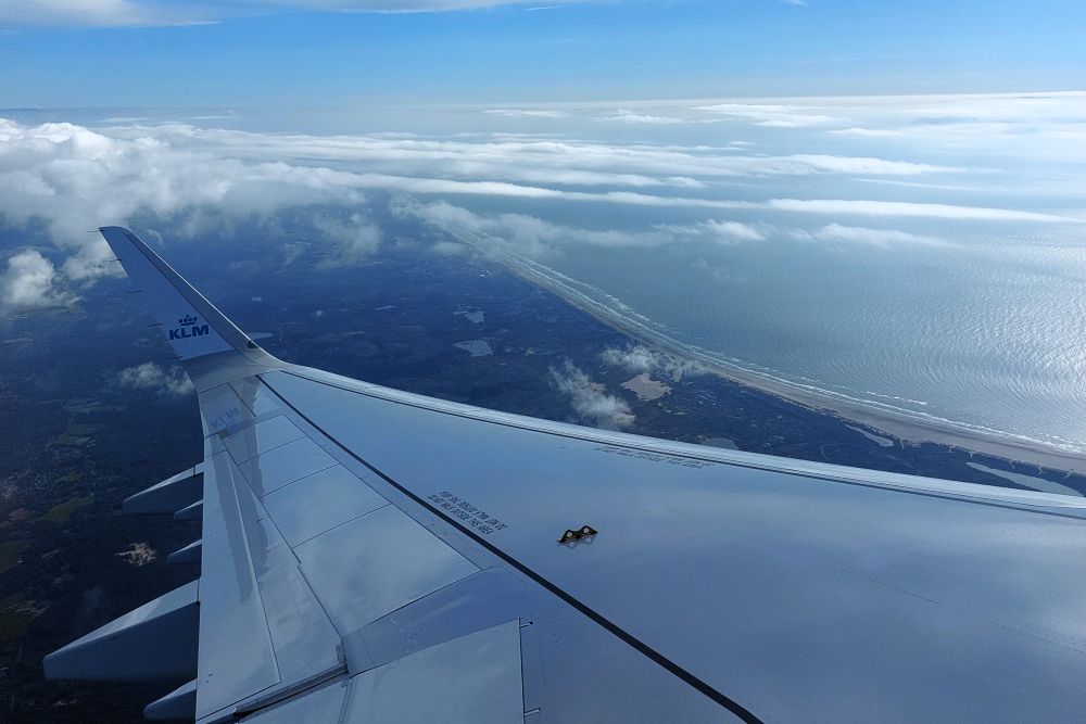 aile d'avion dans le ciel avec la mer en dessous