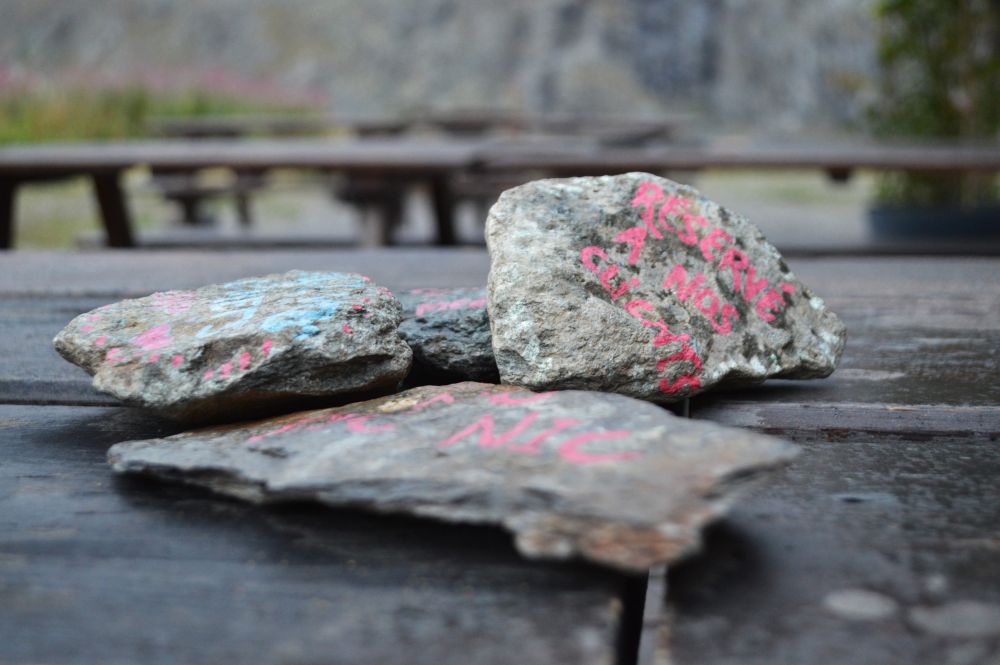 messages écrits sur des cailloux sur une table extérieure du refuge
