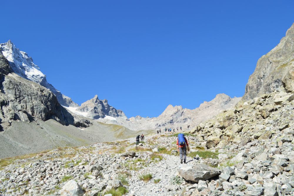 randonneurs dans un paysage minéral dans les Alpes